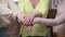 Close-up handstack of three unrecognizable adult Caucasian women indoors. Positive happy friends stacking hands standing