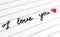 Close-up handwritten phrase `I love you` and red heart.