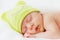 Close up happy baby girl new born sleeping in green hat