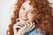 Close up of happy beautiful girl with curly ginger hair smiling looking at camera. White background.