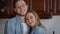 Close-up of happy Caucasian young couple looking at each other with love turning to camera smiling. Loving affectionate