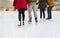 Close up of happy friends skating on ice rink