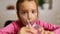 Close up of happy little girl drinking glass fresh water in kitchen