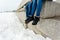 Close-up of a happy and loving couple foot traveler sitting on the granite waterfront. A pair in winter shoes and warm sweaters an