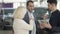 Close-up of happy mature Caucasian couple talking with car dealer in showroom. Positive successful clients discussing