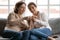 Close up happy mature mother teaching grownup daughter to knit