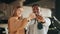 Close up of happy multicultural couple posing at modern dealership center with keys in hands. African man and caucasian