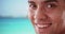 Close up of happy smiling Hispanic Millennial tourist by the ocean on beach
