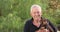 Close-up of a happy, smiling senior man holding his cute little dog