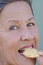 Close up happy woman biting sweet cookie snack