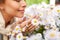 Close up of happy woman smelling chamomile flowers