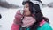 Close-up of happy woman smelling and drinking tea at winter ski resort in slow motion. Portrait of charming beautiful