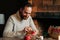 Close-up of happy young man writing number on red bag making paper bags from kraft paper for advent calendar on