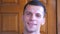 Close up of happy young sportsman looking into camera with positive emotions on his face indoor. Portrait of strong