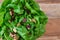Close up of head of fresh butter lettuce with sliced almond and dried cranberry salad topper, in a white bowl on a wood background