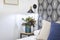 Close-up of headboard decorating the bedside table with a blue vase with plant and vintage lamp