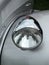 Close up of the headlamp of an elegant silver colored stylish 1930s vintage automobile