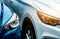 Close up headlamp light of blue and white SUV car. Blue car parked beside white car. Automotive industry concept. Electric car