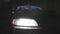 Close up for a headlight of a parked car being turned off at night. Action. Details of a vehicle, front bumper and car