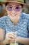 Close up headshot of beautiful woman drinking cool beverage in glass