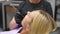 Close-up headshot of pretty blonde female patient sitting in stomatology seat with open mouth during unrecognizable