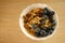 close-up healthy food white cup on light table, oatmeal, blueberries, nuts, almonds, peanuts , raisins, dried fruits, raw food