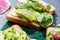 Close up of healthy vegetarian toasts with radish, basil and avocado on cloth.