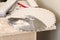 Close-up of a heap of fine carpentry dust near a working circular saw and on disks for a circular saw, selective focus