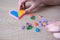 Close-up of heart, children`s hands creating perler bead patterns, make flag of ukraine using thermomosaic technique, perler bead