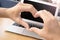 Close up of heart from hands of a young girl on a laptop in a cafe outside,love technology