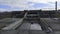 Close-up of helipad near the large gray architectural complex and two staircases against blue cloudy sky in early spring