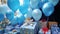 A close-up of helium-filled balloons in vs, adorned with \'Happy Birthday\' messages and tied to gift boxes