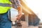 Close-up helmet of Construction worker or civil engineer holding safety white helmet and construction drawing against the