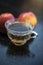 Close up of herbal apple and cinnamon tra on wooden surface in a transparent cup with raw apple.