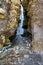 Close-up of hidden Gljufrafoss seen from cliffs flowing through stream