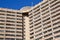 Close Up of High Rise Apartment Building Against Blue Sky