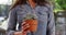 Close up of Hispanic woman in casual shirt holding cactus outside on sunny day