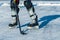 Close-up of hockey skates, stick and puck on ice
