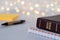 Close-up of holy bible book with golden letter text with spiral notebook, pen and paper notes with blurred bokeh background