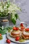 Close-up of homemade appetizing muffins, garnished with strawberries and kiwi on a wooden background. Vertical