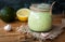 Close-up of homemade creamy avocado dressing in a jar on wooden background