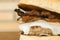 Close up on homemade hamburger with cheese and bacon over wooden cutting board and brick background