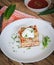 Close-up of homemade lasagna with sour cream and fresh chives on wooden background