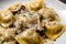 Close-up of homemade mushroom ravioli with truffle oil and grated Parmesan cheese on top