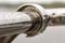 Close-up of horizontal metal wet shiny pipe with big rain water drops on blurred abstract background