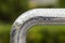 Close-up of horizontal metal wet shiny pipe with big rain water drops on blurred abstract background