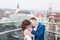 Close-up horizontal portrait of the hugging newlyweds on the roof. The panorama of the Lviv.