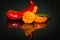 Close-up of hot chili peppers lying ob black reflectin background