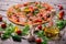 A close-up of hot margarita pizza on a rustic table background. Whole Italian pizza with vegetables and olive oil.