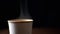 Close up, Hot Steam Rising from a Paper Cup of Hot Coffee on a Black Background